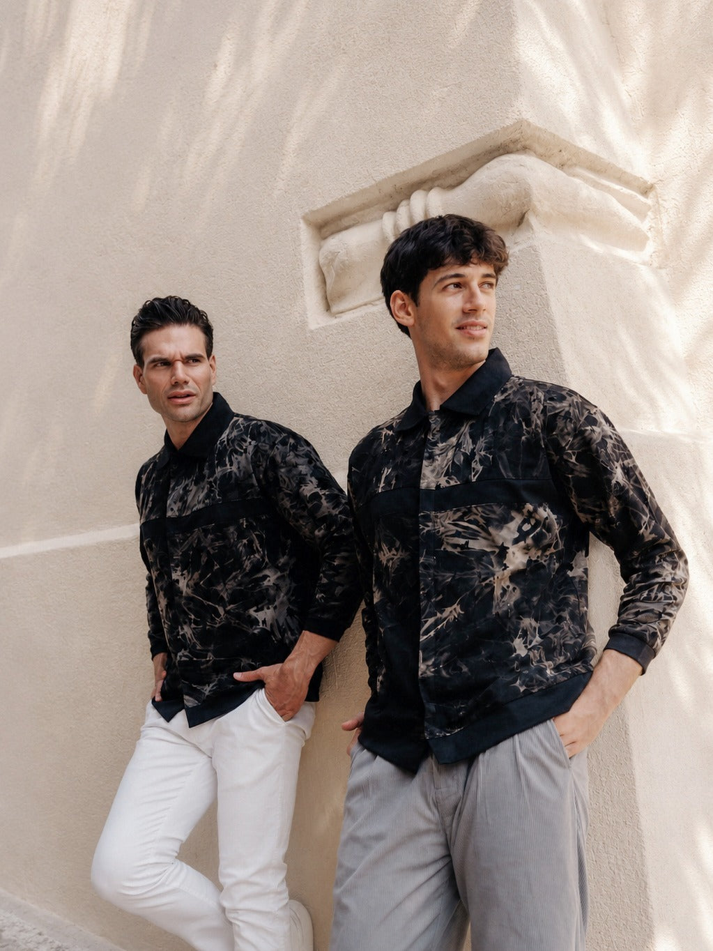 The overshirt in Steel Gray and Buff Orange, worn against a wall in Greece