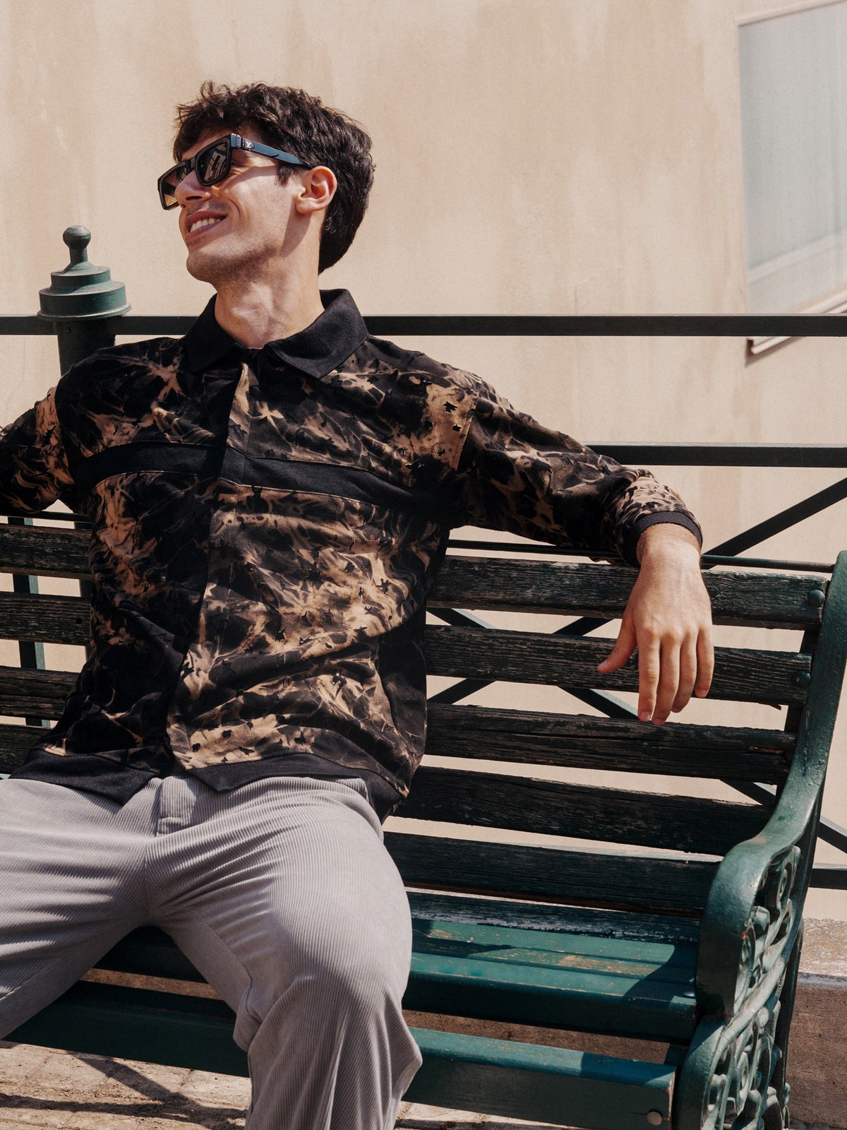 Tonal Abstract Print Overshirt in Buff Orange, seated on a bench in Greece